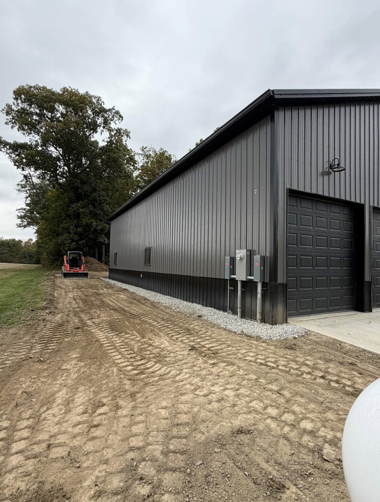 Graded ground and gravel border around a metal shop